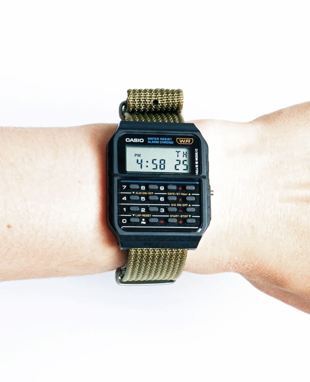 Reloj Casio calculadora con correa NATO verde fotografiado en uso